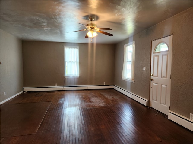 foyer entrance with dark wood-type flooring, ceiling fan, and a baseboard radiator