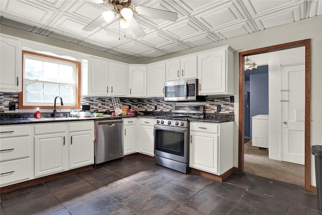 kitchen with stainless steel appliances, dark countertops, an ornate ceiling, and a sink