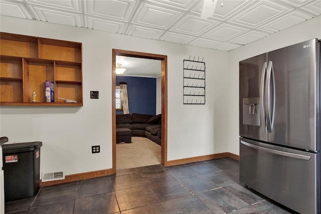 kitchen with an ornate ceiling, stainless steel refrigerator with ice dispenser, open shelves, visible vents, and baseboards