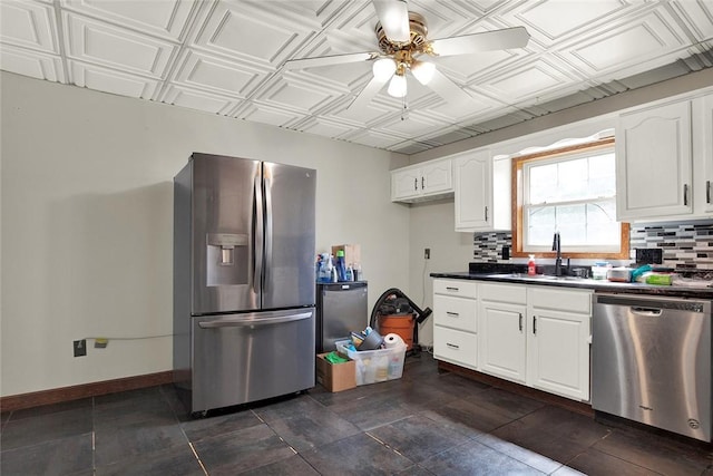 kitchen featuring appliances with stainless steel finishes, dark countertops, an ornate ceiling, and white cabinetry