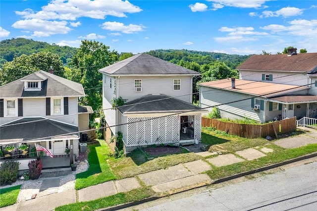 traditional style home with a shingled roof and fence