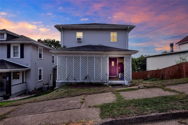 view of front of home with cooling unit and fence