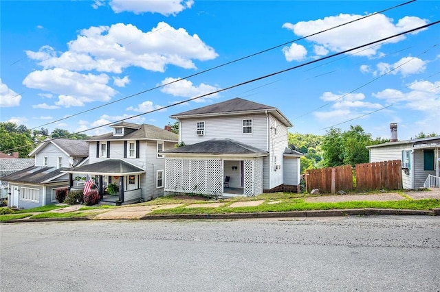 view of front of house featuring covered porch and fence