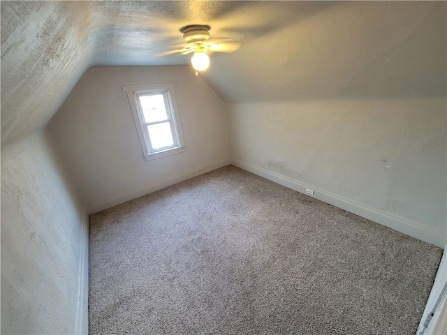 additional living space featuring lofted ceiling, a textured ceiling, carpet, and ceiling fan