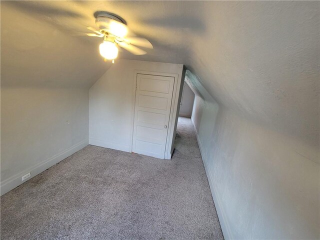 additional living space with ceiling fan, vaulted ceiling, a textured ceiling, and light carpet