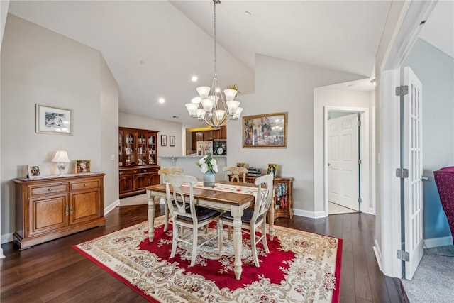 dining area with dark wood-type flooring, lofted ceiling, and a chandelier