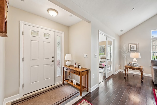 foyer featuring lofted ceiling, dark hardwood / wood-style flooring, and a healthy amount of sunlight