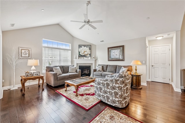 living room with ceiling fan, vaulted ceiling, and dark wood-type flooring