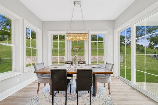 sunroom / solarium featuring a notable chandelier and a healthy amount of sunlight