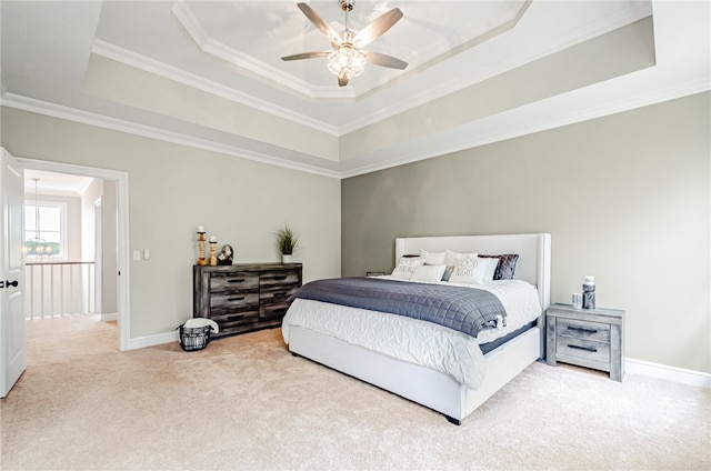 bedroom with ceiling fan, a raised ceiling, carpet, and crown molding