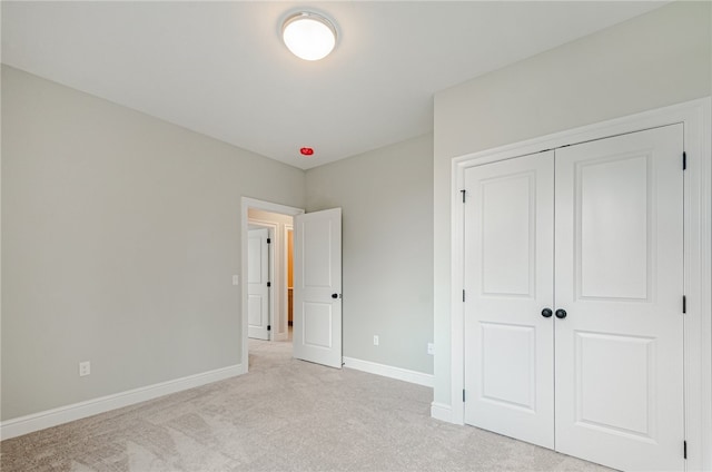 unfurnished bedroom featuring a closet and light carpet