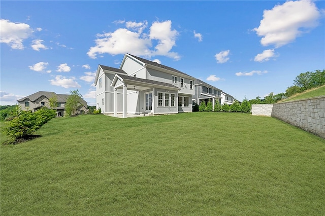 rear view of house with a patio and a yard