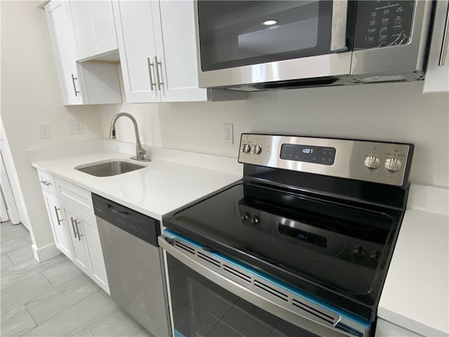 kitchen featuring light tile patterned floors, sink, stainless steel appliances, and white cabinets