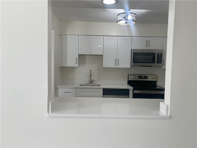 kitchen with sink, stainless steel appliances, and white cabinets