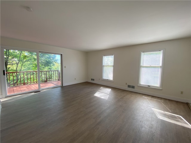 unfurnished room with hardwood / wood-style flooring and a healthy amount of sunlight