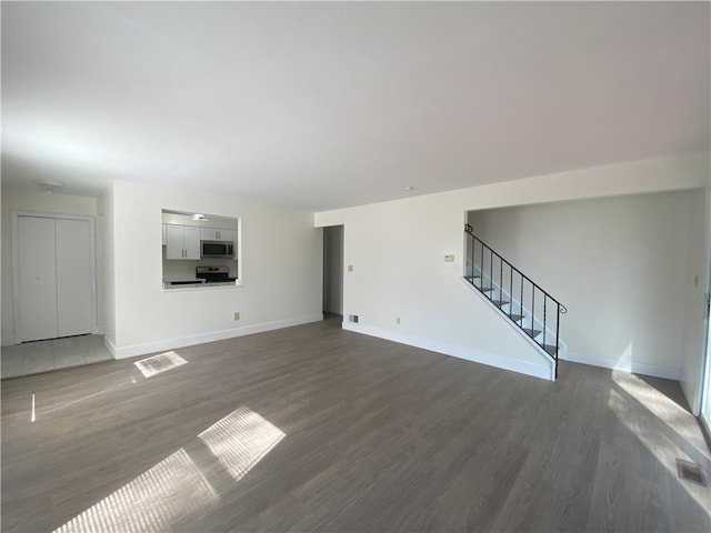 32 Bracken Pl, Plum Boro, PA 15239 - unfurnished living room with dark wood-style floors, stairway, and baseboards