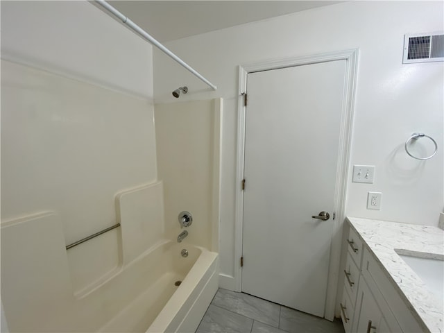 bathroom with washtub / shower combination, vanity, and tile patterned floors