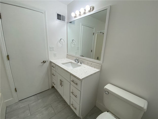 bathroom featuring tile patterned floors, vanity, and toilet