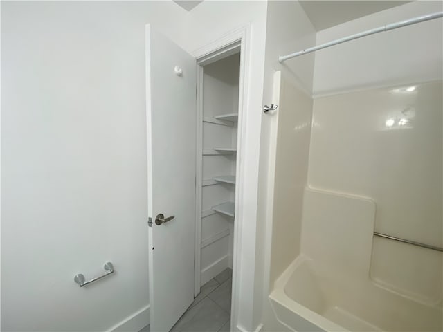 bathroom featuring tile patterned flooring and  shower combination