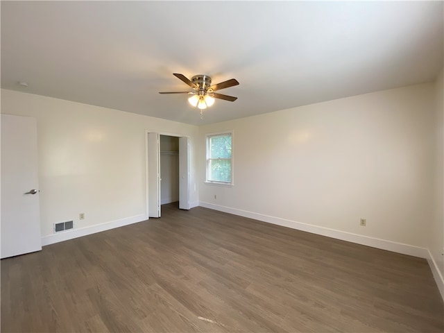 unfurnished bedroom featuring a closet, ceiling fan, and dark wood-type flooring