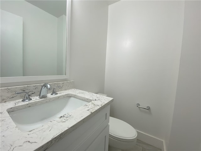 bathroom featuring tile patterned floors, vanity, and toilet