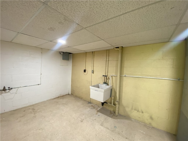 basement featuring a drop ceiling and sink