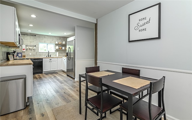 dining room featuring light wood-type flooring and sink