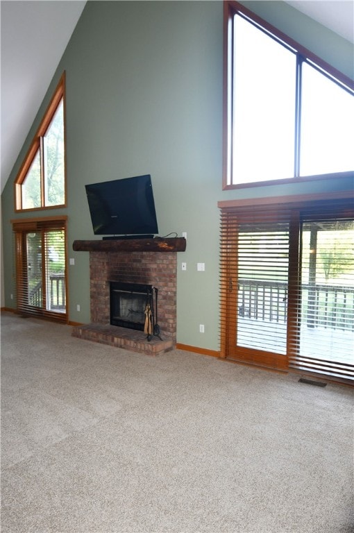 unfurnished living room featuring carpet floors, high vaulted ceiling, and a brick fireplace