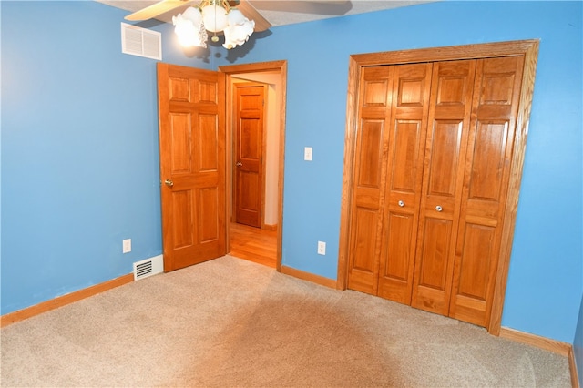 unfurnished bedroom with ceiling fan and light colored carpet