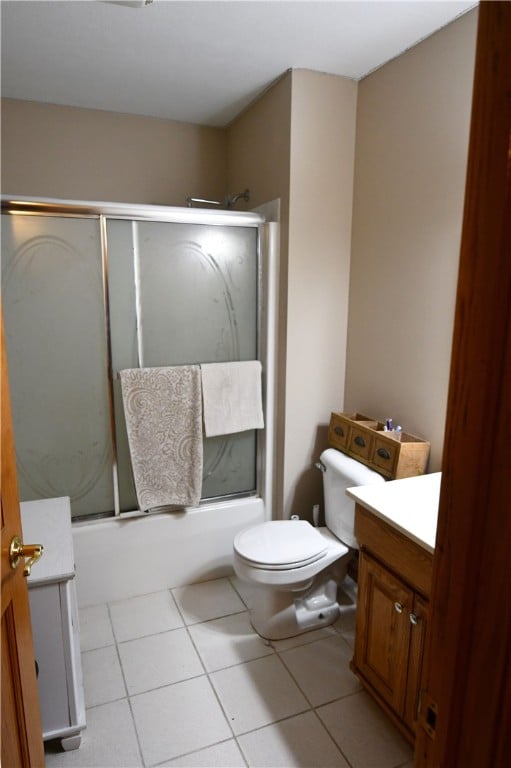 full bathroom featuring tile patterned flooring, shower / bath combination with glass door, toilet, and vanity