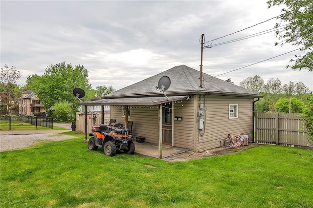 back of property featuring a storage shed and a yard