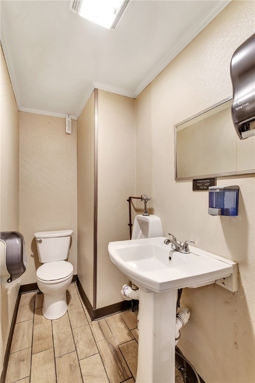 bathroom with ornamental molding and toilet