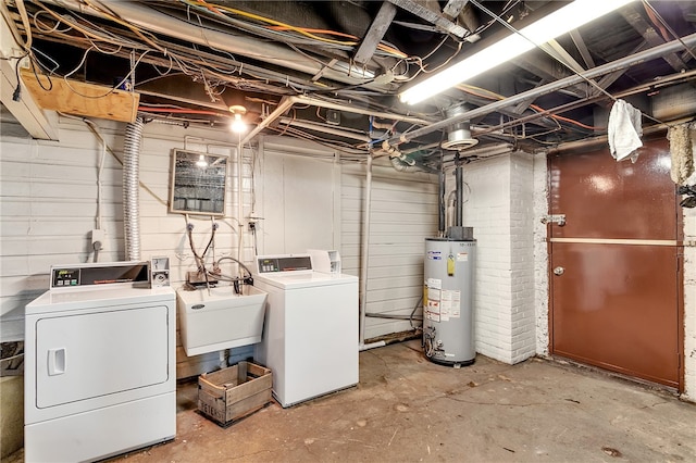 clothes washing area featuring washer and dryer, sink, and water heater