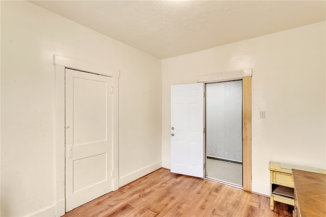 unfurnished bedroom featuring light wood-type flooring and a closet