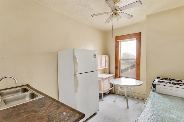 kitchen featuring sink, ceiling fan, a textured ceiling, and white refrigerator