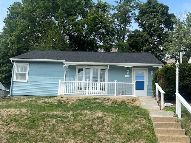 single story home with covered porch and a front yard