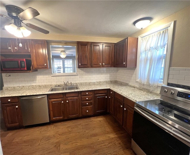 kitchen featuring sink, stainless steel appliances, light hardwood / wood-style floors, and backsplash