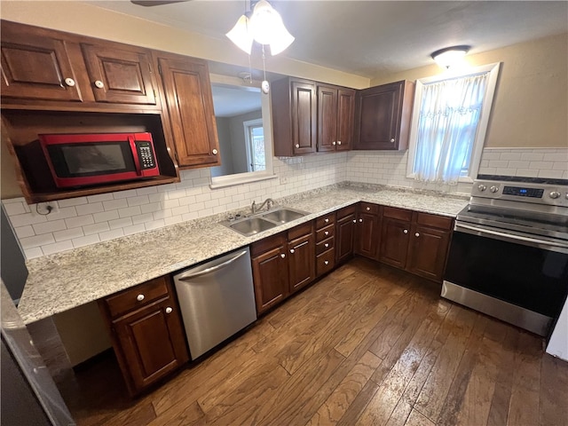 kitchen featuring sink, backsplash, appliances with stainless steel finishes, and dark hardwood / wood-style floors