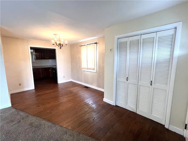 interior space featuring a notable chandelier, a closet, and dark wood-type flooring