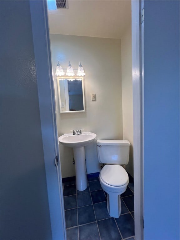 bathroom with toilet and tile patterned floors