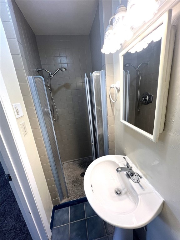 bathroom with sink, tile patterned flooring, and tiled shower