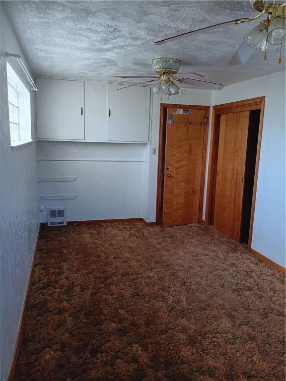 interior space with a textured ceiling, carpet flooring, and ceiling fan