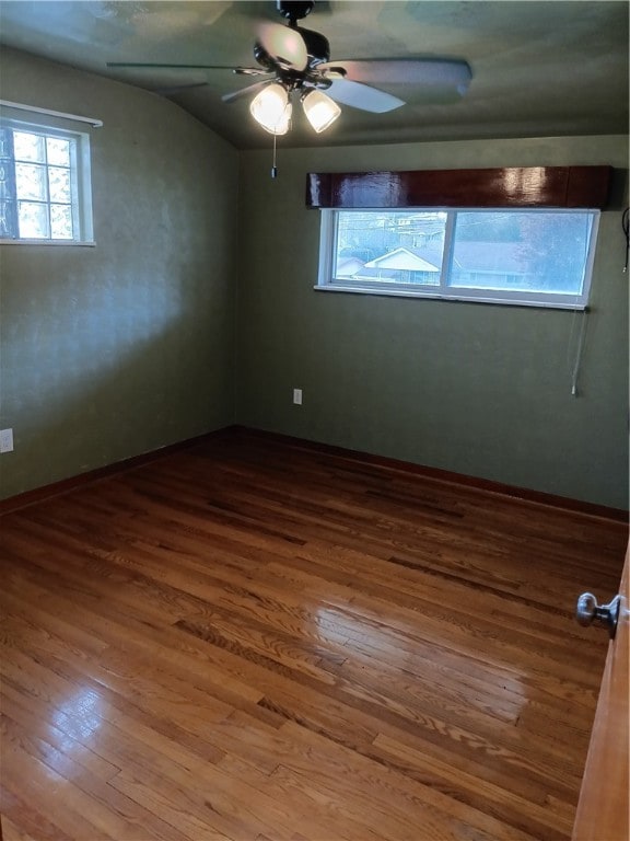 spare room featuring hardwood / wood-style floors, vaulted ceiling, and ceiling fan