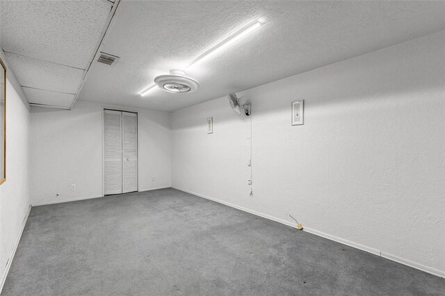 basement featuring carpet and a textured ceiling