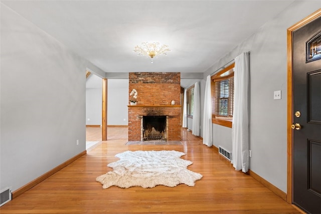 unfurnished living room featuring a fireplace and light hardwood / wood-style floors