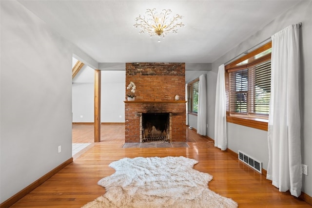 living room featuring a brick fireplace and hardwood / wood-style flooring