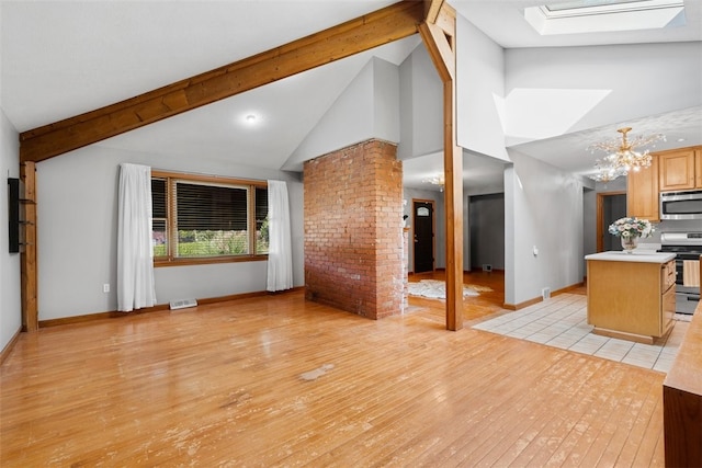 unfurnished living room featuring light hardwood / wood-style flooring, an inviting chandelier, a skylight, high vaulted ceiling, and beamed ceiling