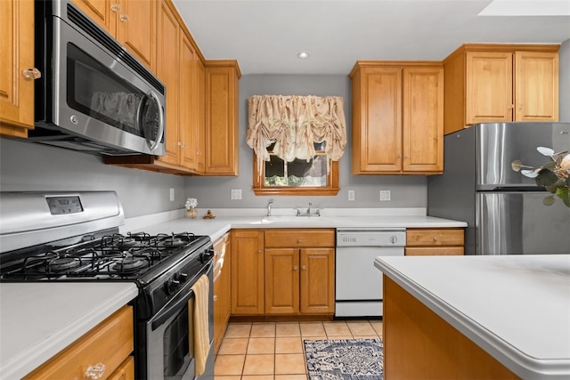 kitchen with appliances with stainless steel finishes, sink, and light tile patterned floors