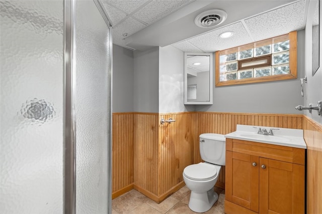 bathroom featuring a paneled ceiling, vanity, and wood walls