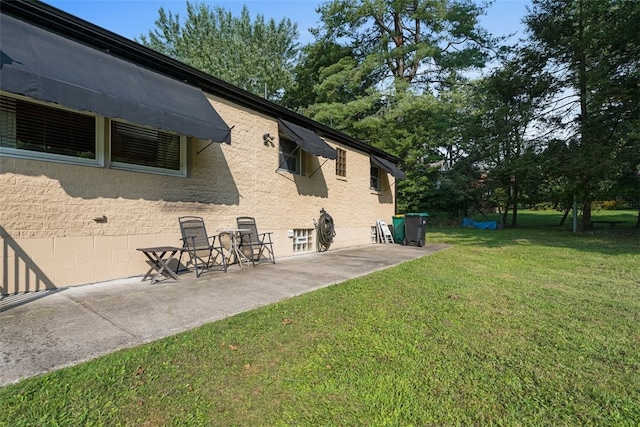 view of home's exterior featuring a patio and a lawn